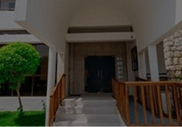 The entrance to a house with a wooden staircase.