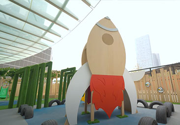 A wooden play structure with a rocket on it.