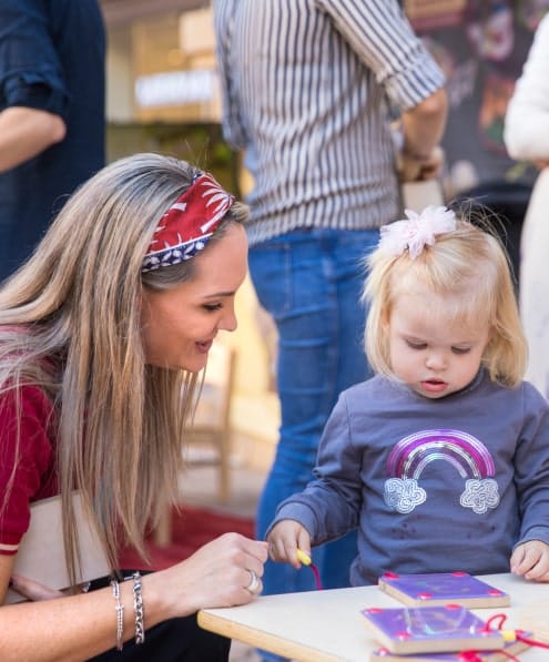 A woman with a little girl at a table.