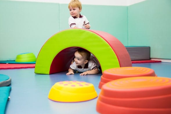 Two children playing in a play area with colorful toys.