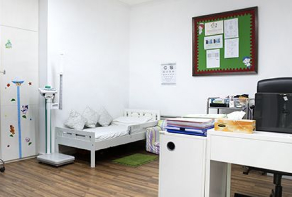 A child’s room with a bed, desk and chair.
